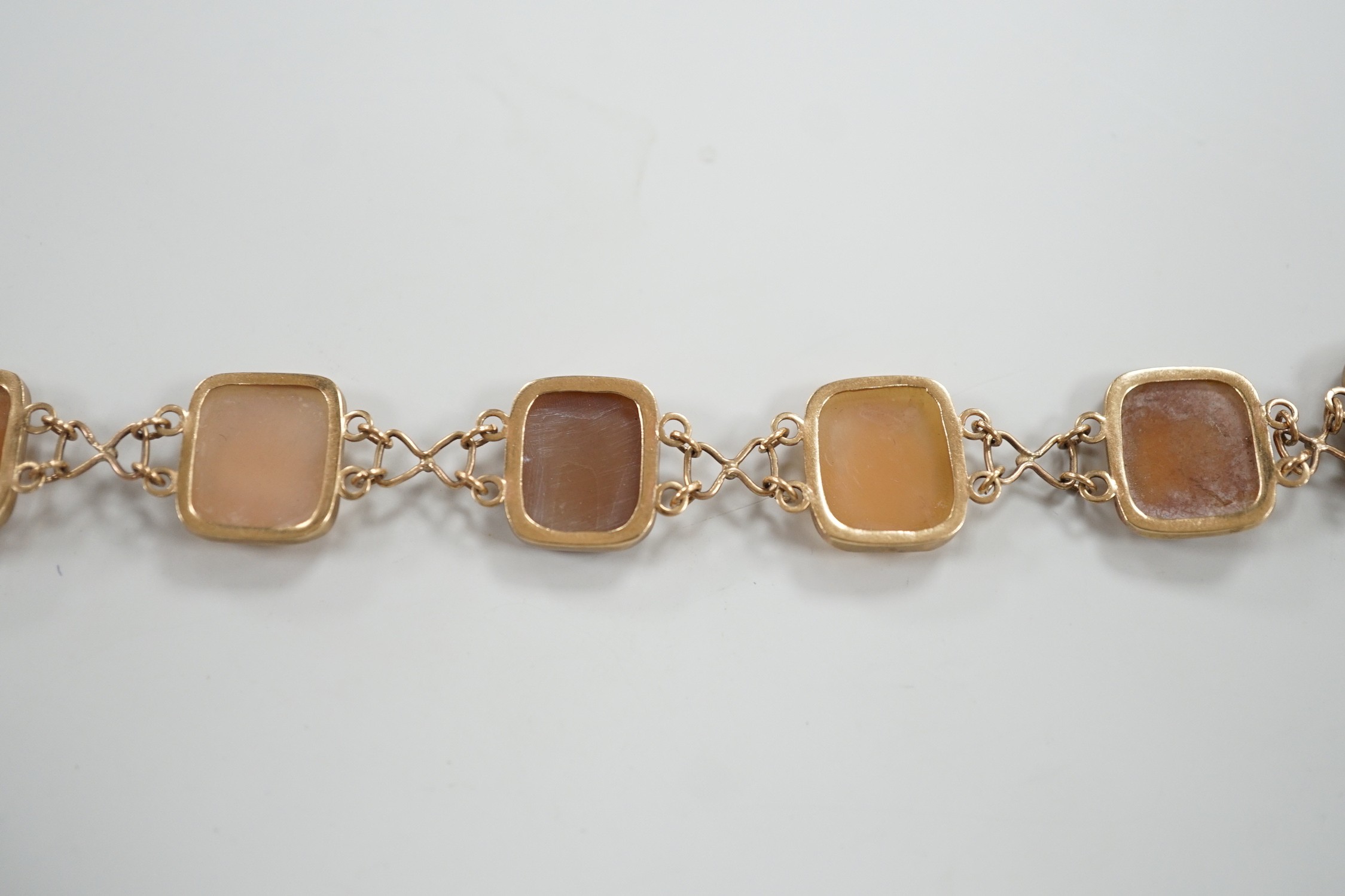 A 1970's 9ct gold and seven cameo panel set bracelet, carved with busts of ladies or flowers, 18cm, gross weight 10.3 grams.